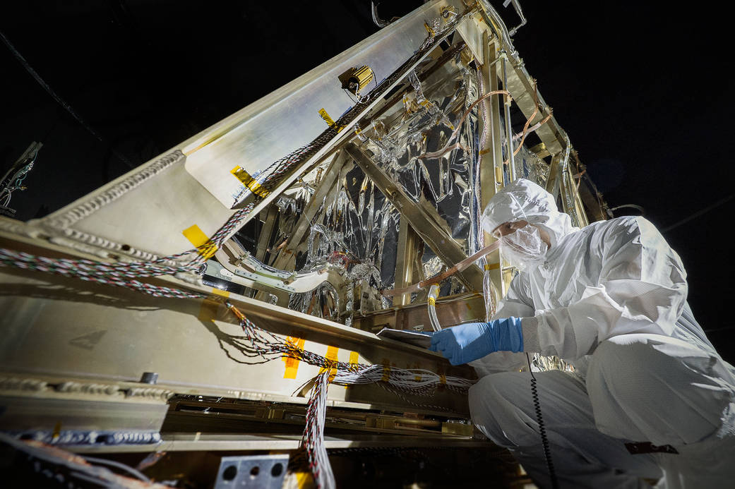 NASA engineer in clean suit inspecting instruments