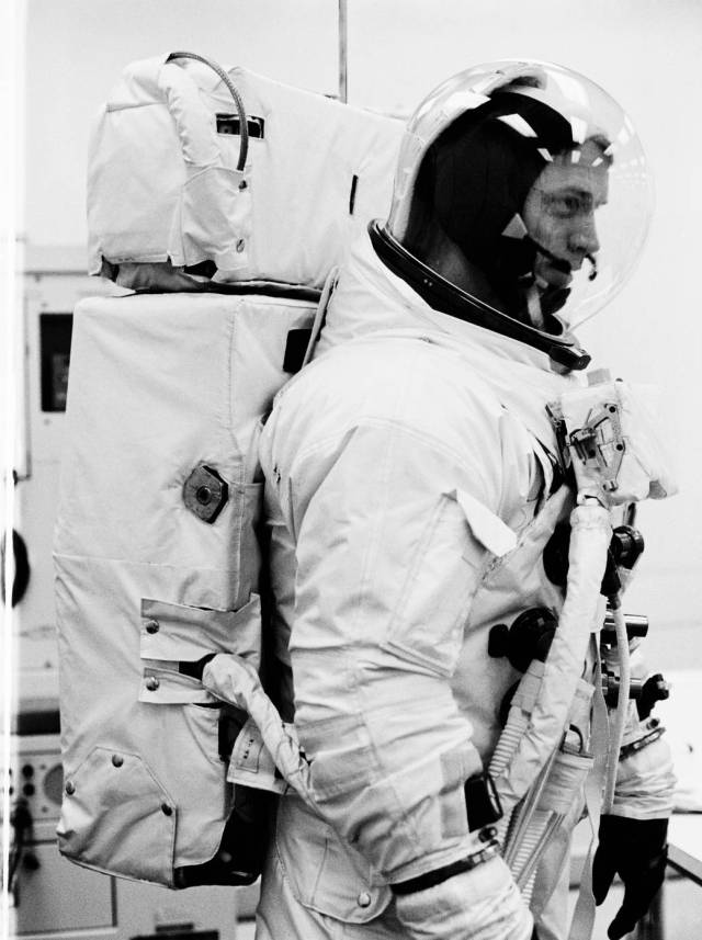 Closeup black and white photo of standing astronaut in Apollo spacesuit