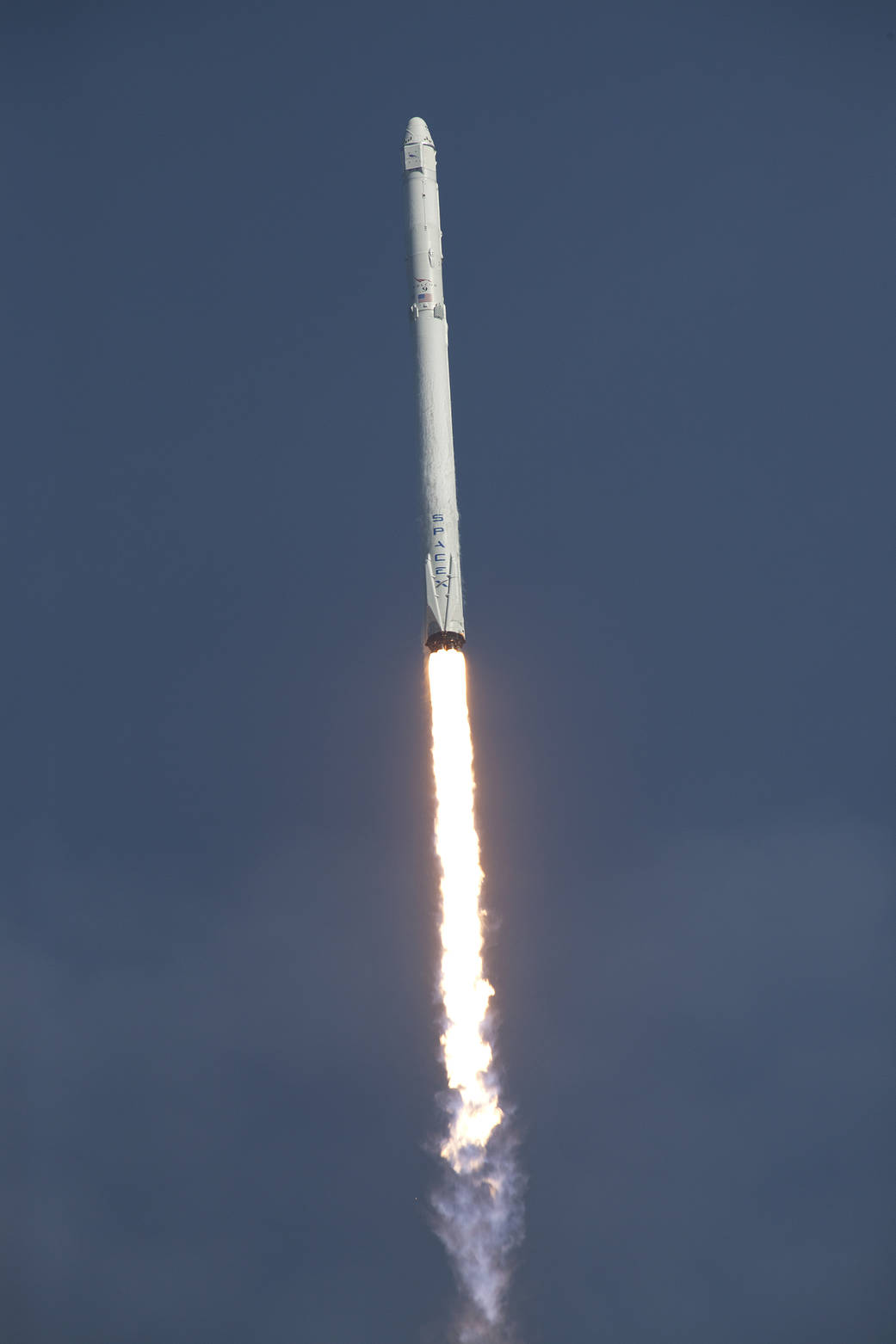 SpaceX Falcon rocket with Dragon capsule streaks upward moments after liftoff