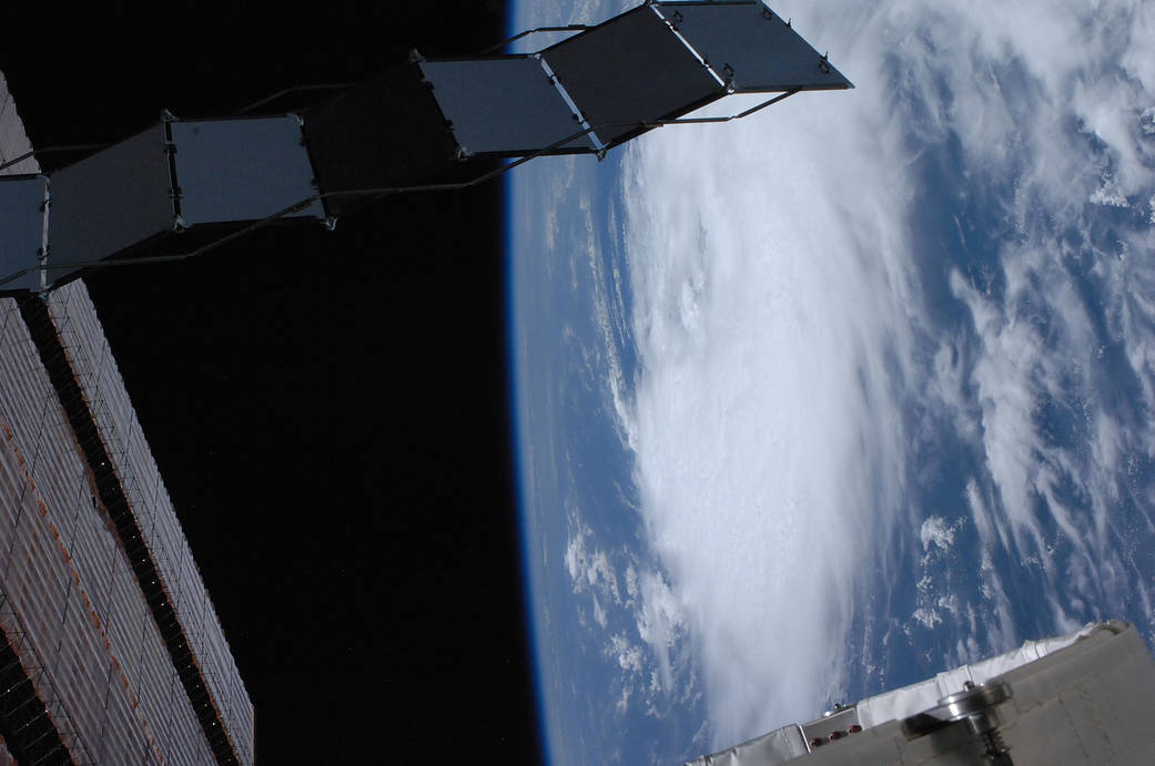 Hurricane photographed from low Earth orbit with space station solar array at left of frame