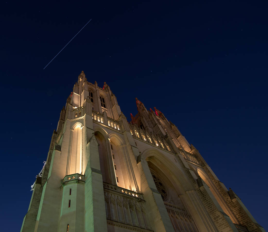 Streak of light in sky above cathedral