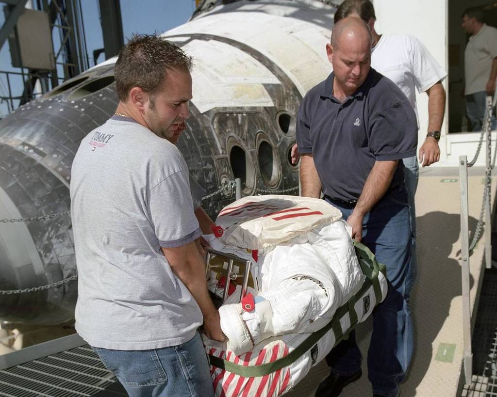 STS-114 Technicians Remove Extravehicular Mobility Unit from Shuttle Discovery