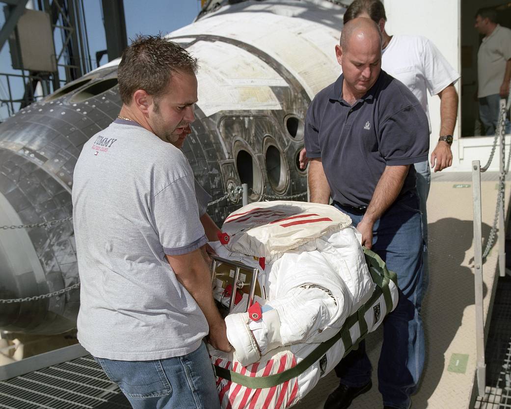 STS-114 Technicians Remove Extravehicular Mobility Unit from Shuttle Discovery