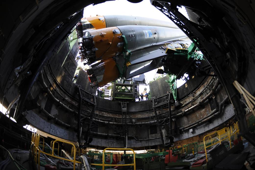 Fisheye view from below of horizontal Soyuz rocket at launch pad being raised to vertical