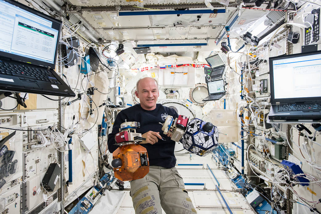 Astronaut Jeff Williams inside space station's Kibo Laboratory with floating SPHERES satellites