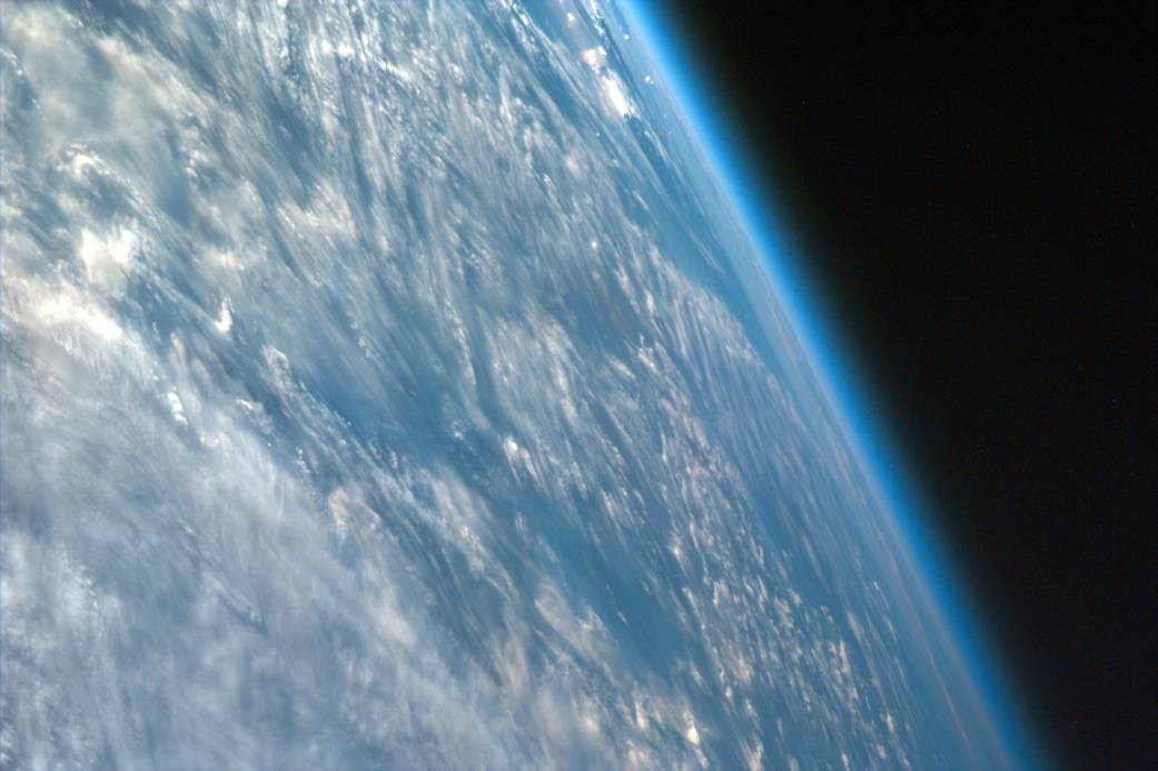 Area of Earth with clouds and edge of atmosphere photographed from space