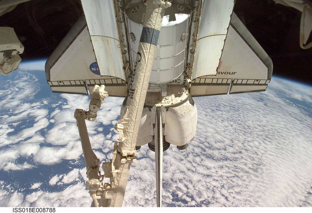 View of the bottom front half of shuttle Endeavour docked to the space station with Earth below