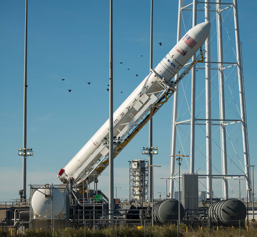 Orbital ATK Antares rocket at angle as it is raised to vertical on launch pad