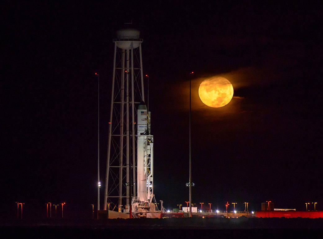 The Orbital ATK Antares rocket, with the Cygnus spacecraft onboard, is seen on launch Pad-0A as the moon sets, predawn, Saturday