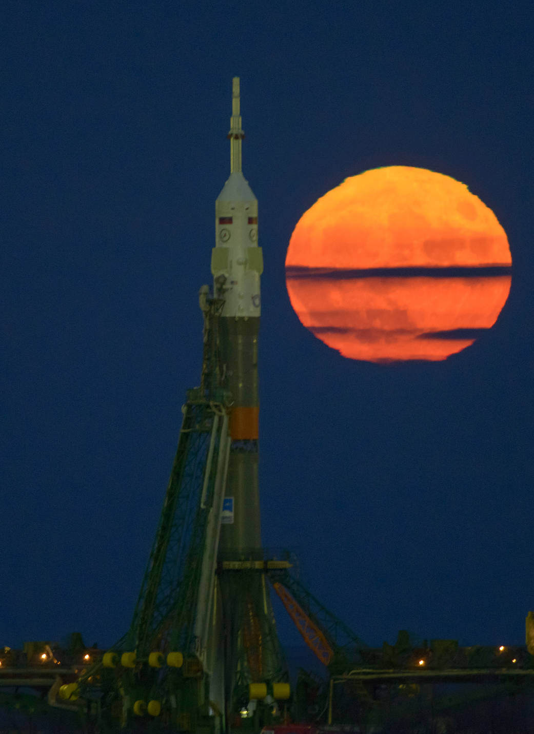 Moon rising at left and Soyuz rocket at launchpad