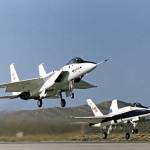 Two jets seen on takeoff just above the  runway.