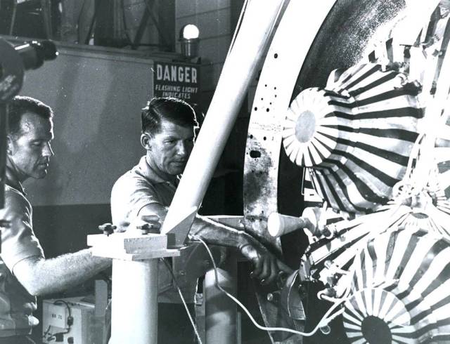 Gordon Cooper and Wally Schirra check out the MA-8 spacecraft in the Hangar S white room.