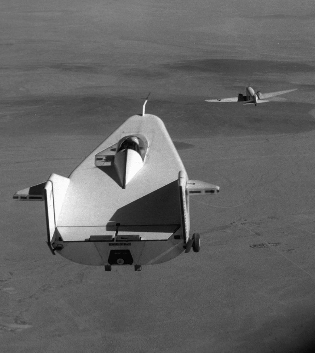 The M2-F1 Lifting Body is seen here being towed behind a C-47 at the Flight Research Center, Edwards, CA. 