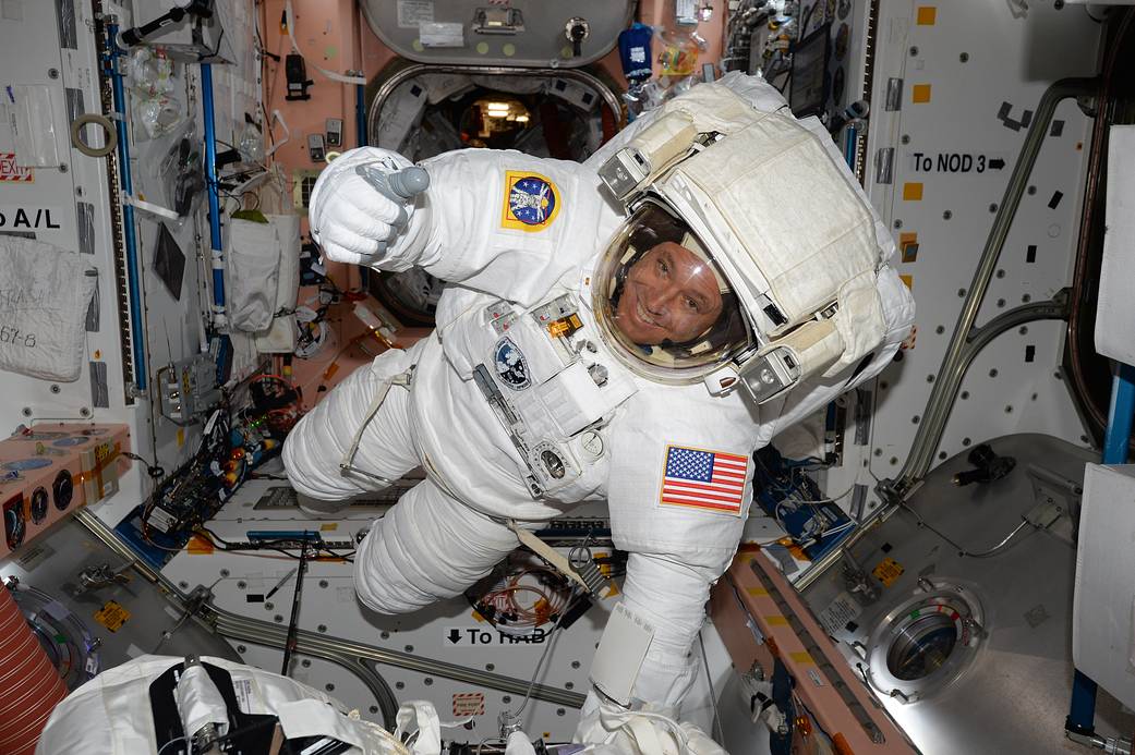 Astronaut in spacesuit floats inside space station module