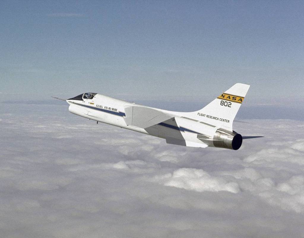 Aircraft flying above white clouds.