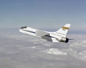 Aircraft flying above white clouds.