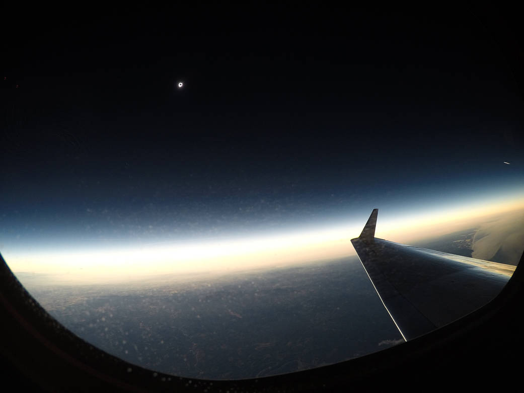 Eclipse viewed from aircraft with horizon below