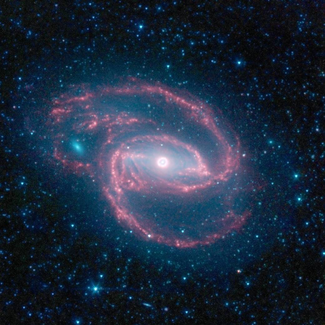 Spiral shaped galaxy in bright white and rose light against stars and deep space