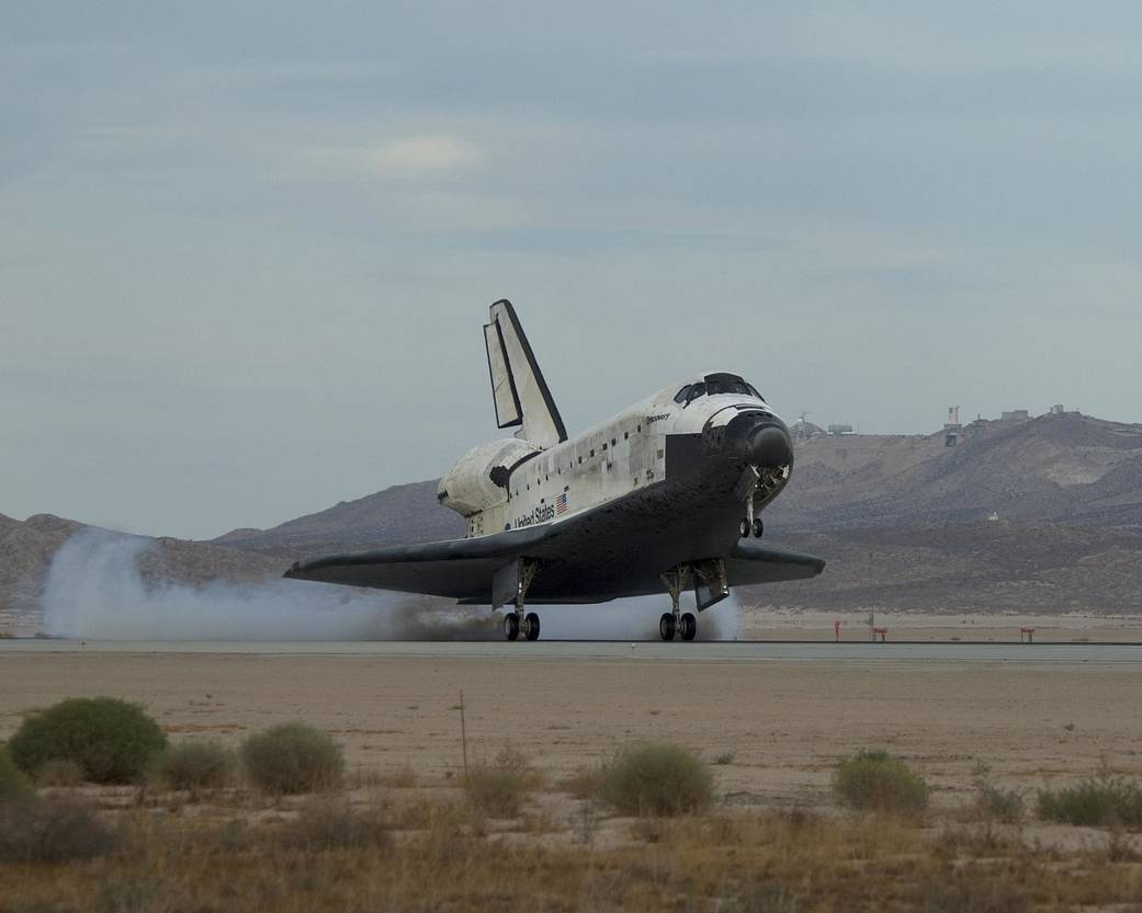 Shuttle Discovery touches down on runway in daytime