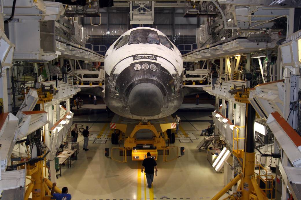 Shuttle Atlantis from front with nose and wings visible inside facility