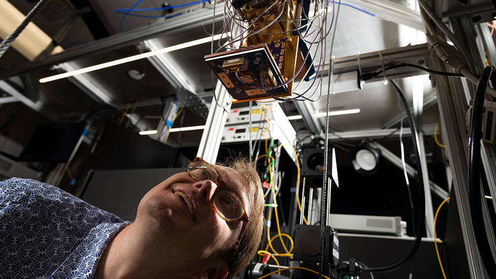 Matt Shaw, is shown here inspecting a PEACOQ mounted to a cryosta