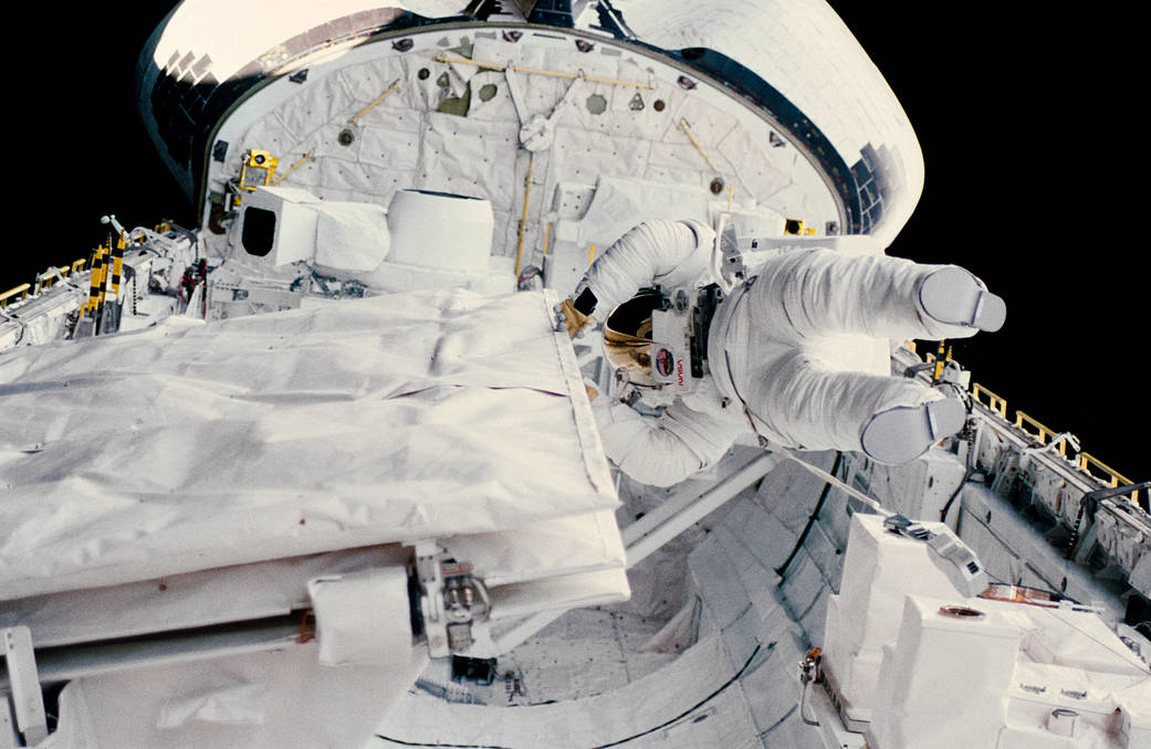 Astronaut Kathryn Sullivan in spacesuit in open payload bay of shuttle Challenger 