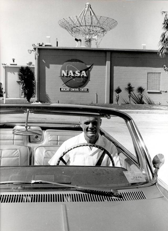 Astronaut John H. Glenn sits in a car in front of the east side of the Mercury Mission Control building. 