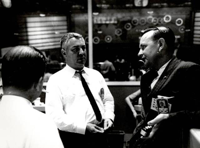 Inside Mercury flight control, Walter C. Williams, associate director for Project Mercury operations (center) listens to Christopher Kraft, flight director (right).