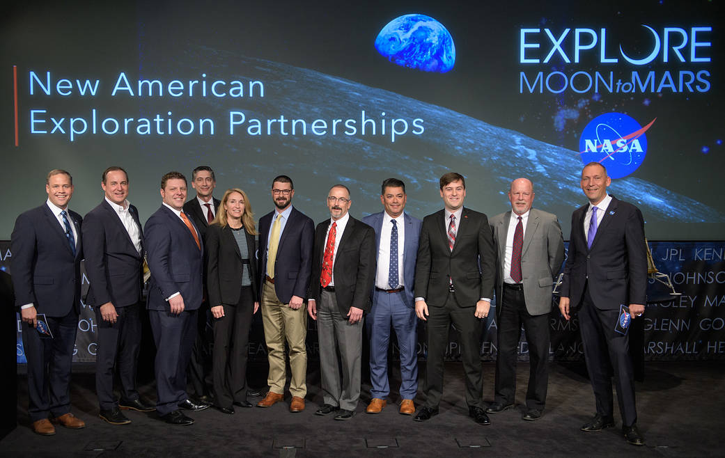 Group poses for photo on auditorium stage