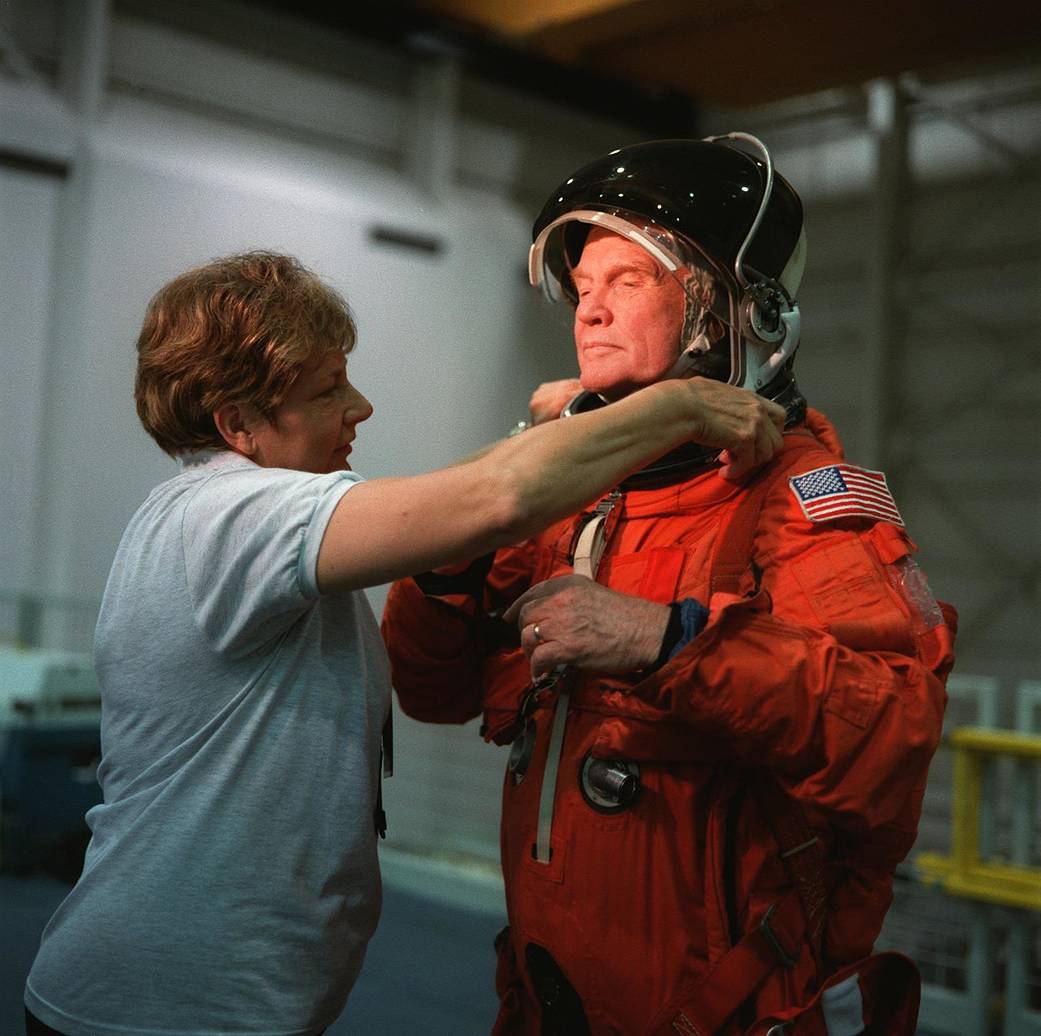 John Glenn gets help donning his launch and entry suit during training for his STS-95 space shuttle mission.