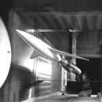 A black and white photo of an engineer making calibrations on the model inside the 6x6 foot supersonic wind tunnel.