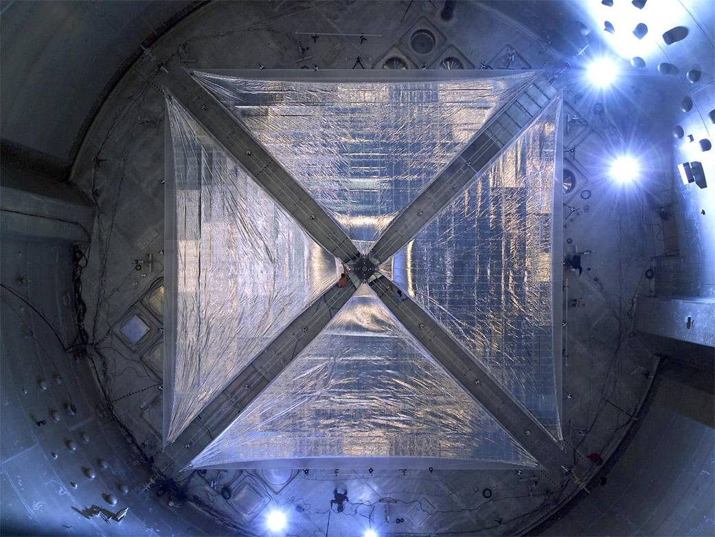 View from below of square, silver solar sail with diagonal support structures