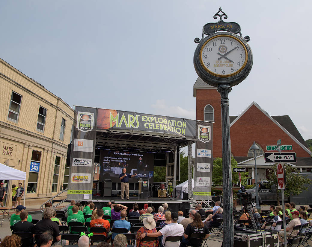 Crowd listening to man talking on stage