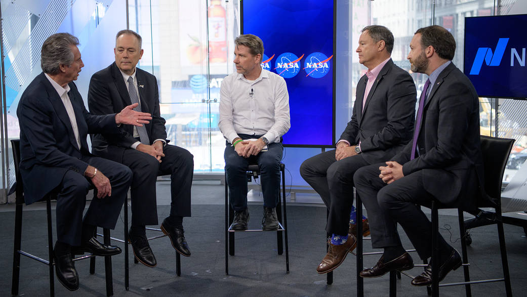 A Nasdaq moderator, center, talks with Bigelow Aerospace, LLC Founder and President Robert Bigelow, left