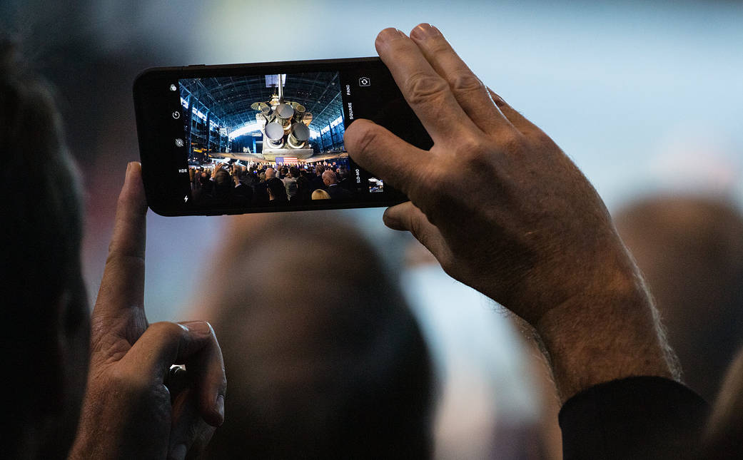A member of the audience takes a picture with their phone as Vice President Mike Pence is introduced 