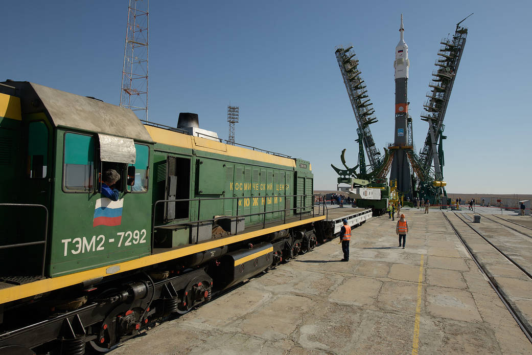 The gantry arms close around the Soyuz rocket after it was raised into vertical position on the launch pad, Sept. 23, 2019.