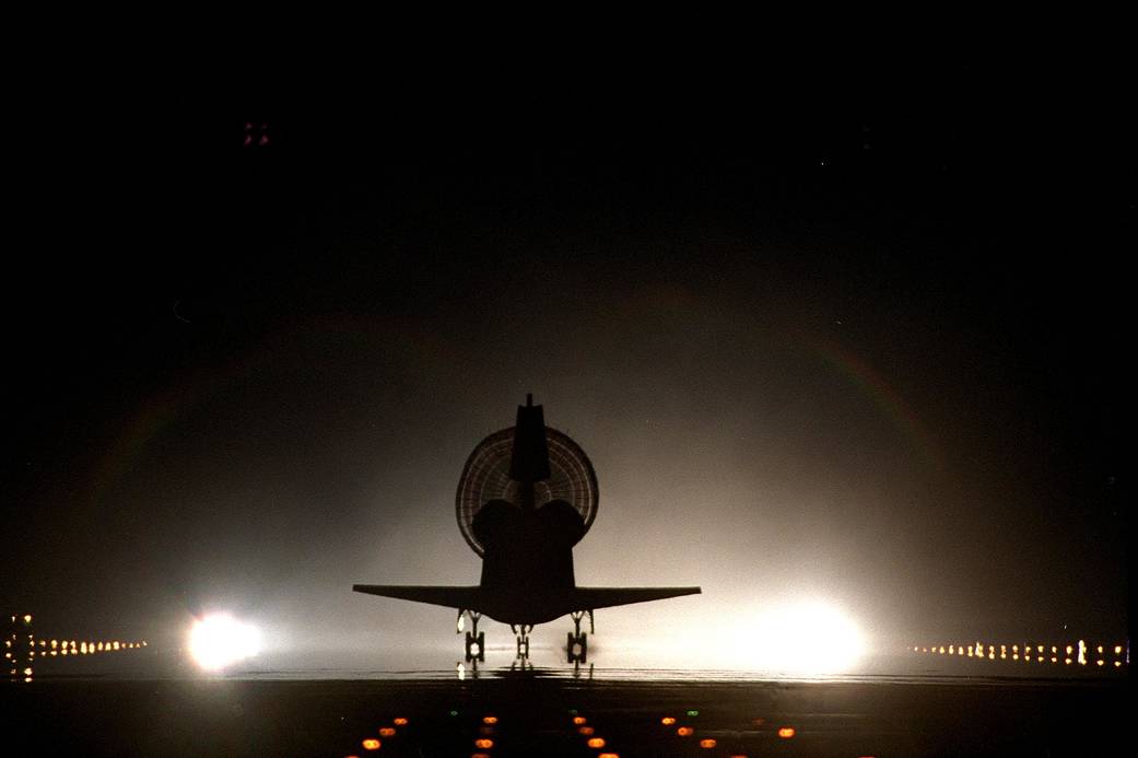 With its drag chute fully deployed, space shuttle Discovery lands on Kennedy's brightly lighted Shuttle Landing Facility runway 15, completing the STS-96 mission.