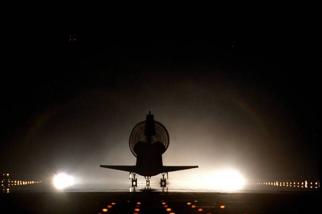 With its drag chute fully deployed, space shuttle Discovery lands on Kennedy's brightly lighted Shuttle Landing Facility runway 15, completing the STS-96 mission.
