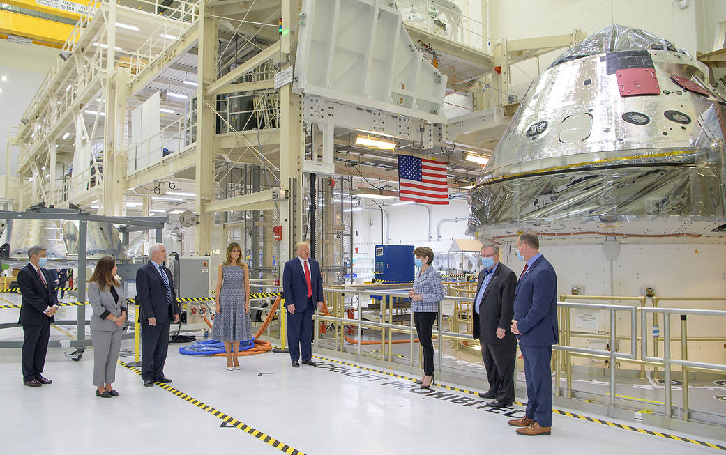 The president and vice president are seen with others in front of the Artemis I capsule.