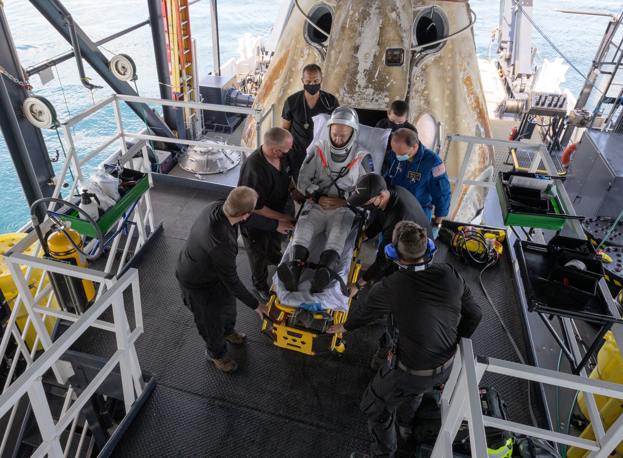 NASA astronaut Douglas Hurley is helped out of the SpaceX Crew Dragon Endeavour spacecraft