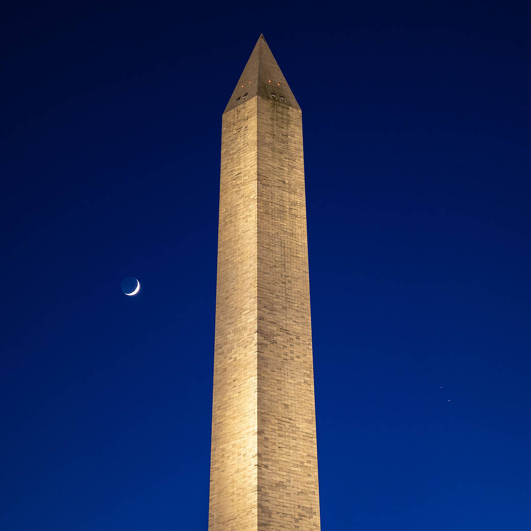 The Moon, left, Saturn, upper right, and Jupiter, lower right, are seen after sunset with the Washington Monument, Dec. 17
