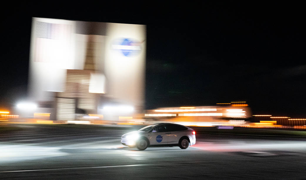 A vehicle carrying two members of NASA’s SpaceX Crew 4 mission passes by the Vehicle Assembly Building as it returns to the Neil A. Armstrong Operations and Checkout Building, Wednesday, April 20, 2022