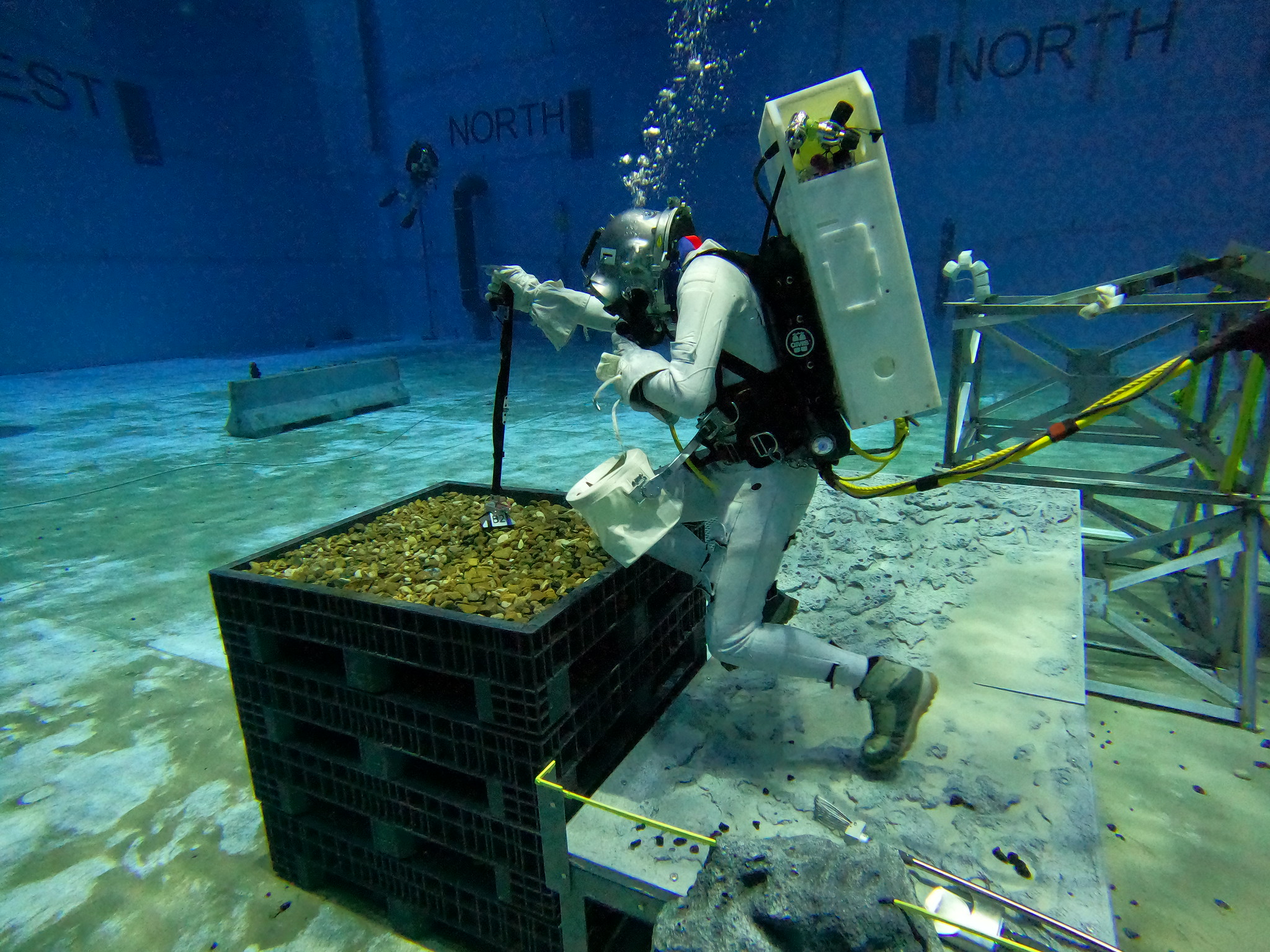 Diver uses tool to pick up rocks under water
