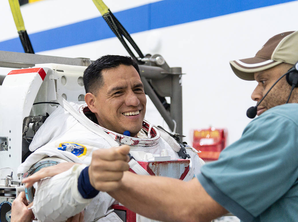 NASA Astronaut Frank Rubio gets help putting on a spacesuit 