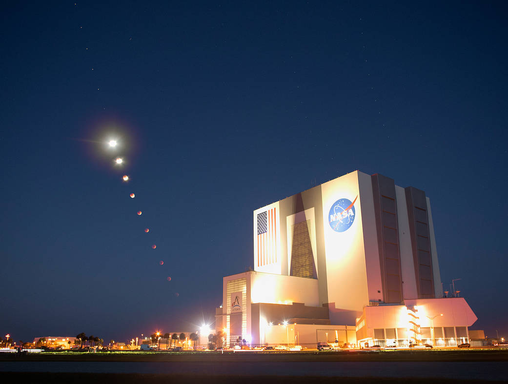 This composite made from ten images shows the progression of the Moon during a total lunar eclipse above the Vehicle Assembly Building, Nov. 8, 2022, at NASA’s Kennedy Space Center in Florida. Visible trailing the Moon in this composite is Mars.