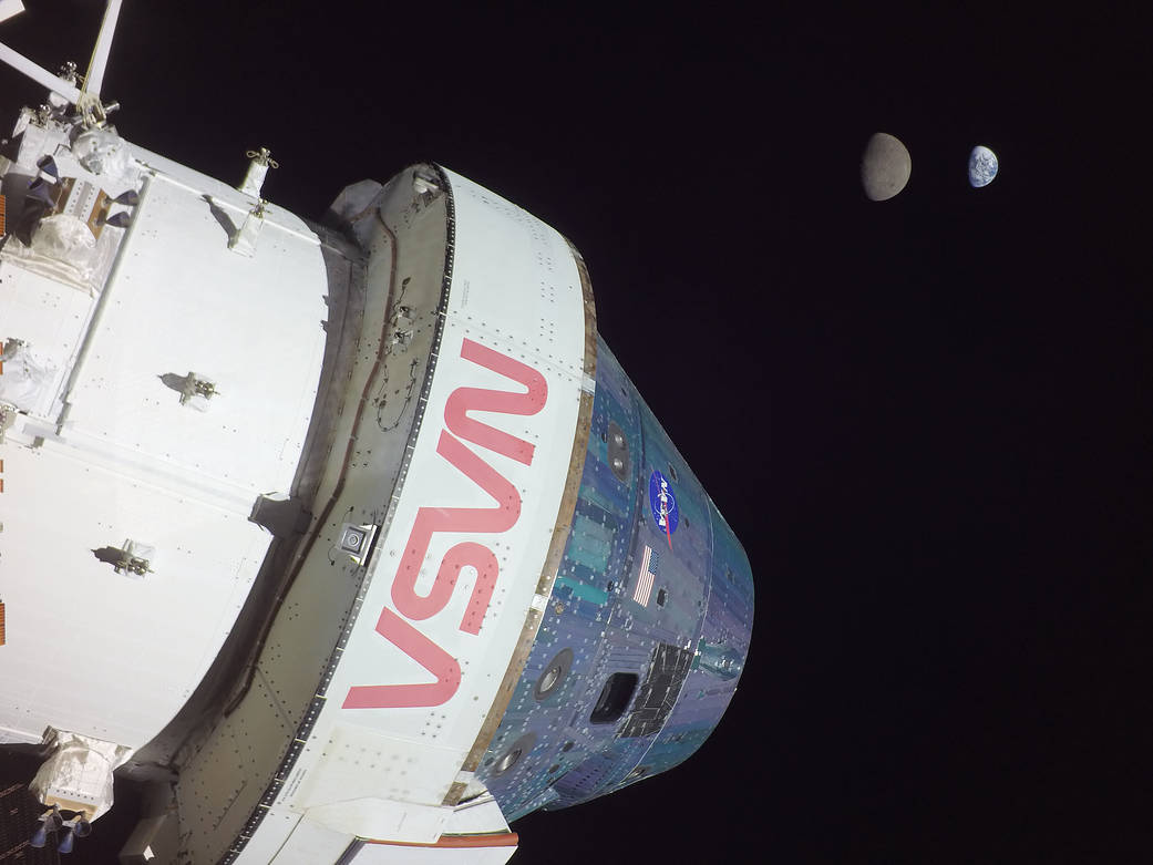  In this image, Orion captures a unique view of Earth and the Moon, seen from a camera mounted on one of the spacecraft's solar arrays.