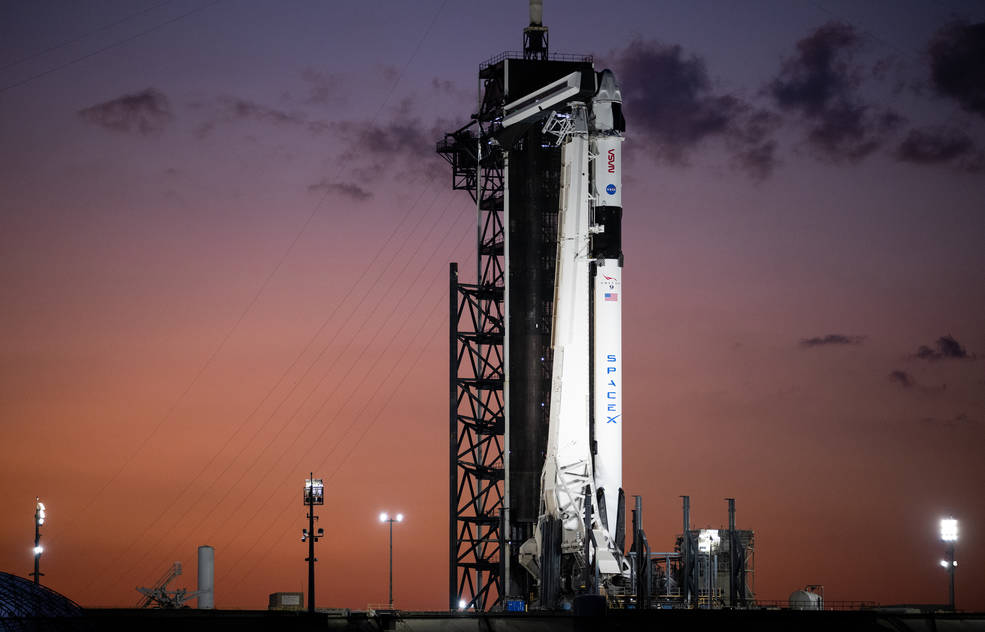 A SpaceX Falcon 9 rocket with the company's Dragon spacecraft on top is seen at sunset on the launch pad at Launch Complex 39A.