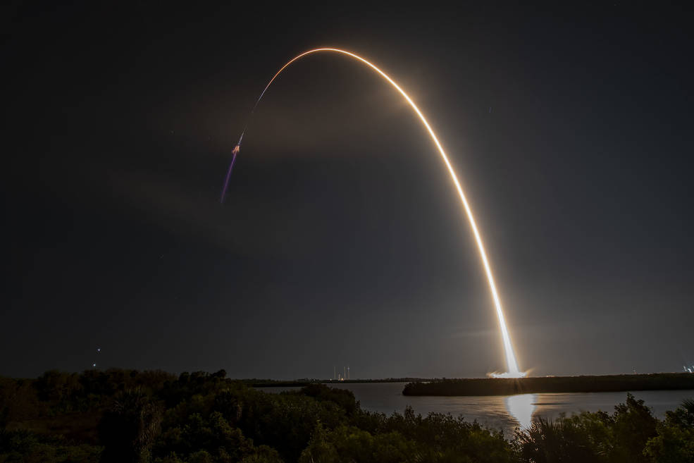Creating a golden streak in the night sky, a SpaceX Falcon 9 rocket soars upward after liftoff from Launch Complex 39A at NASA’s Kennedy Space Center in Florida.