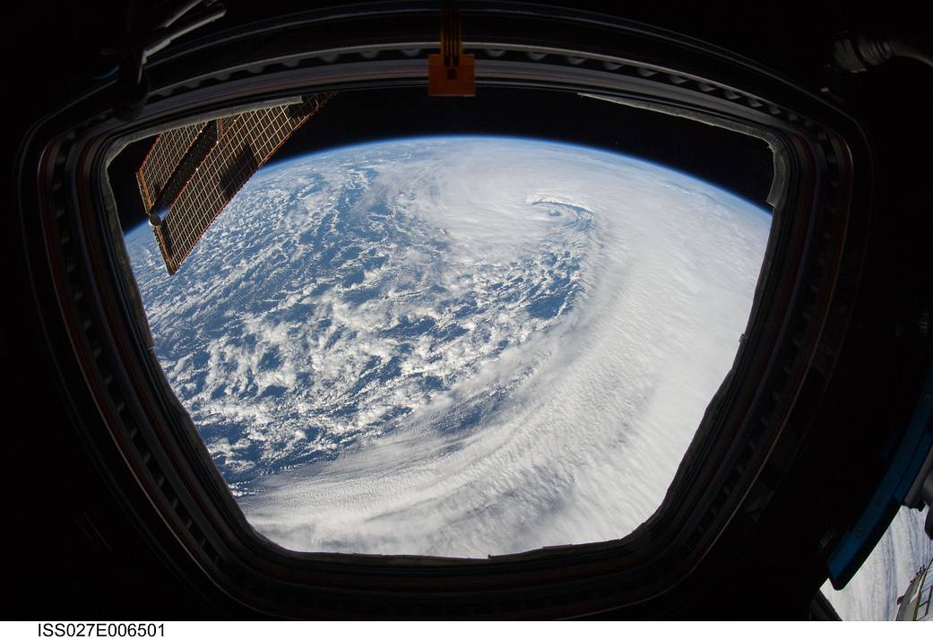 Storm on Earth viewed from window on space station with solar array visible at left