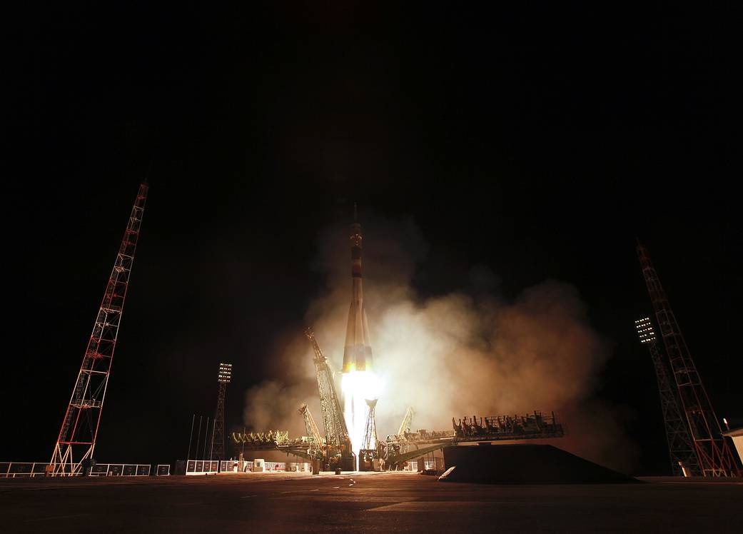 Fiery nighttime liftoff of Soyuz rocket with launch tower pulled back from rocket